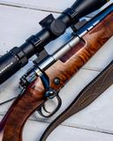 Winchester Model 70 Super Grade Review: Rifle Calibers, Price, Pros and Cons

The Winchester Model 70 Super Grade is more than just a bolt-action rifle—it’s a symbol of American craftsmanship, hunting heritage, and precision engineering. Revered by generations of hunters and sport shooters, the Super Grade variant elevates the legendary Model 70 platform with premium materials, refined aesthetics, and performance-focused enhancements.

Whether you’re stalking elk in the Rockies or punching paper at 300 yards, the Super Grade delivers reliability, accuracy, and timeless style.

🔧 Overview and Build Quality

First introduced in 1936, the Model 70 quickly earned the nickname “The Rifleman’s Rifle”. The Super Grade version represents the pinnacle of this lineage, combining controlled round feed, MOA trigger system, and Grade V/VI walnut stocks with elegant finishes.

Core Features:

• Action Type: Bolt-action with Pre-64 style controlled round feed
• Bolt: Jeweled body with Mauser-style claw extractor
• Safety: Three-position wing safety
• Trigger: MOA (Minute of Angle) adjustable trigger system
• Stock: Grade V/VI black walnut or AAA maple with shadow-line cheekpiece
• Finish: Polished blued steel, ebony fore-end tip, steel grip cap

The rifle’s one-piece steel bottom metal adds rigidity, enhancing accuracy and durability. The forged steel receiver includes an integral recoil lug, bedded front and rear for consistent zero retention.

⛓️‍💥 Available Modifications and Variants

The Super Grade is available in several configurations, including:

• Super Grade Walnut – Classic black walnut stock with high-gloss finish
• Super Grade Maple – AAA exhibition-grade maple stock with ebony tip
• Super Grade Stainless – Matte stainless steel barrel and receiver
• Super Grade French Walnut – Premium French walnut with deep grain
• Limited Editions – Centennial, 75th Anniversary, and African Safari variants

Each version maintains the core Super Grade features but varies in stock material, finish, and chambering options.

📐 Calibers and Specifications

The Model 70 Super Grade is chambered in a wide range of calibers to suit different hunting needs:

• .243 Winchester
• .264 Winchester Magnum
• .270 Winchester
• 7mm Remington Magnum
• .308 Winchester
• .30-06 Springfield
• .300 Winchester Magnum
• .300 WSM
• .338 Winchester Magnum
• 6.5 Creedmoor
• 6.5 PRC
• 6.8 Western

General Specs:

• Barrel Length: 22”, 24”, or 26” depending on caliber
• Weight: ~7.5 to 8.6 lbs (unloaded)
• Magazine Capacity: 3+1 or 5+1 internal box magazine
• Length of Pull: 13.75”
• Drop at Comb: 1.25”
• Drop at Heel: 2.0”
• Recoil Pad: Pachmayr Decelerator

Barrels are cold hammer-forged, free-floating, and feature a recessed target crown for improved accuracy.

🎯 Effective Range and Hunting Applications

The Super Grade is built for precision and power, making it suitable for a wide range of game:

Game Type	Recommended Caliber	Effective Range	
Varmint/Coyote	.243 Win, 6.5 Creedmoor	200–400 yards	
Deer/Antelope	.270 Win, .308 Win	300–600 yards	
Elk/Moose	.300 Win Mag, 7mm Rem Mag	400–800 yards	
Bear/Buffalo	.338 Win Mag	100–500 yards	

With match-grade ammo and proper optics, shooters report sub-MOA groups at 100 yards and consistent performance out to 600+ yards.

💬 User Reviews: Pros and Cons

✅ Pros

• Exceptional Accuracy: Free-floating barrel and MOA trigger deliver tight groups
• Controlled Round Feed: Reliable cycling in all conditions
• Premium Aesthetics: High-grade wood, polished metal, and classic styling
• Durability: Forged steel receiver and robust construction
• Legacy Value: Collectible and heirloom-worthy

❌ Cons

• Price Point: MSRP ranges from $1,500 to $2,200, depending on model
• Weight: Heavier than synthetic-stocked rifles
• No Factory Optics: Requires separate scope and mounts
• Limited Customization: Not modular like tactical platforms

💵 Pricing and Value

As of 2025, the Winchester Model 70 Super Grade is priced as follows:

• Standard Walnut Model: ~$1,500–$1,600
• Maple Edition: ~$1,550–$1,700
• French Walnut or Limited Editions: ~$1,700–$2,200
• Used Models: ~$1,000–$1,400 depending on condition

While not budget-friendly, the Super Grade offers exceptional value for hunters seeking a rifle that blends performance with heritage.

🧠 Why Hunters and Shooters Choose the Super Grade

• Tradition Meets Technology: Combines classic styling with modern accuracy
• Field-Proven Reliability: Trusted in harsh conditions and big-game hunts
• Craftsmanship: Each rifle is a work of art, not just a tool
• Versatility: Suitable for everything from whitetail to brown bear
• Resale and Legacy: Holds value and often passed down through generations

📚 Final Thoughts

The Winchester Model 70 Super Grade is not just a rifle—it’s a statement. It speaks to those who value precision, tradition, and craftsmanship. Whether you’re a seasoned hunter or a collector of fine firearms, the Super Grade delivers performance that matches its reputation.

From its controlled round feed to its MOA trigger, every detail is engineered for excellence. And with chamberings that span from .243 to .338 Win Mag, it’s ready for any hunt, anywhere.

If you’re looking for a rifle that performs in the field and turns heads at the range, the Super Grade is a timeless choice.